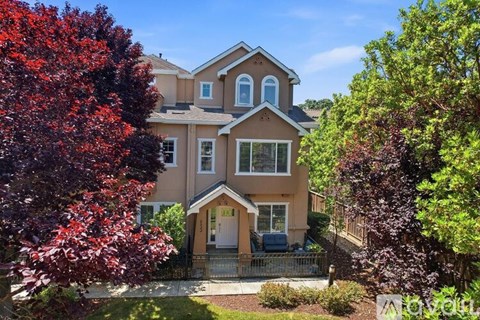 A house with a red tree in front of it.