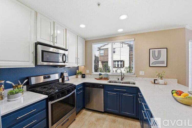 A kitchen with blue cabinets and stainless steel appliances.