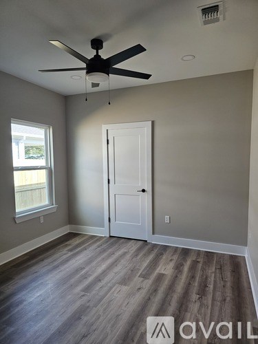 A room with a ceiling fan and a door.