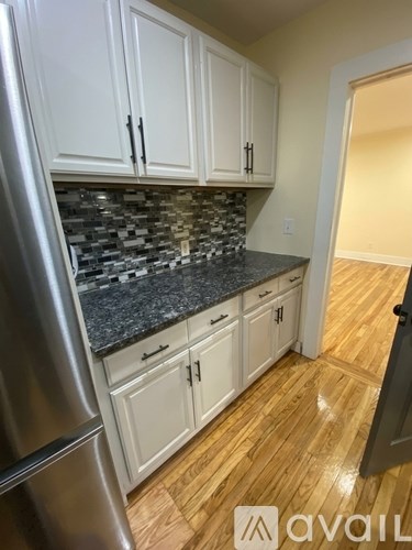 A kitchen with white cabinets and a granite countertop.