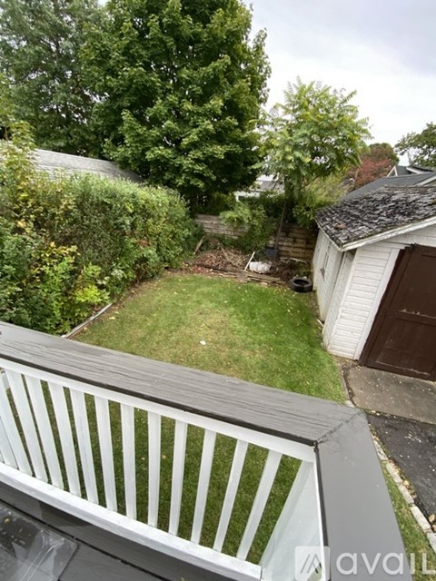 A backyard with a white fence and a shed.