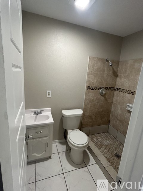 A bathroom with a toilet, sink, and shower.