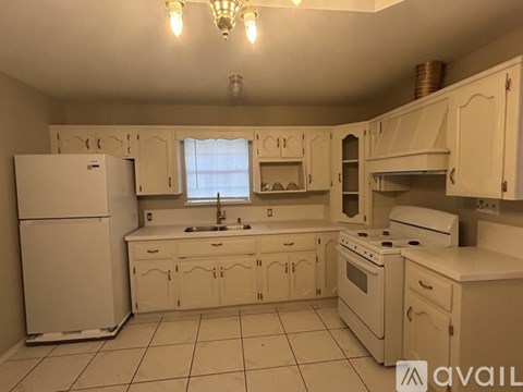 A kitchen with white appliances and cabinets.