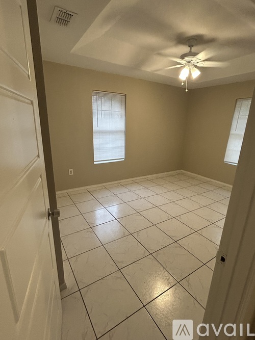 A room with a ceiling fan and tile flooring.
