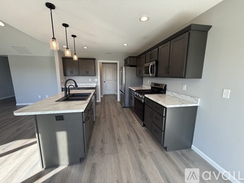 A modern kitchen with dark wood cabinets and a marble countertop.