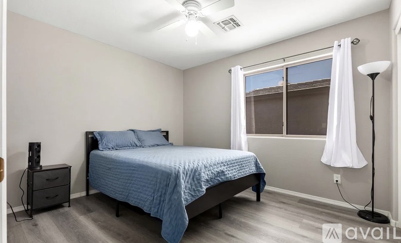 A bedroom with a bed, nightstand, and window.