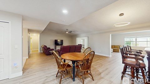 A living room with a wooden table and chairs.