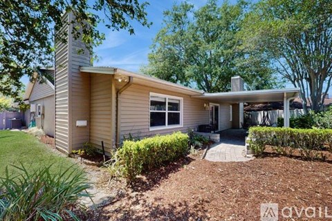A house with a front yard and a tree.