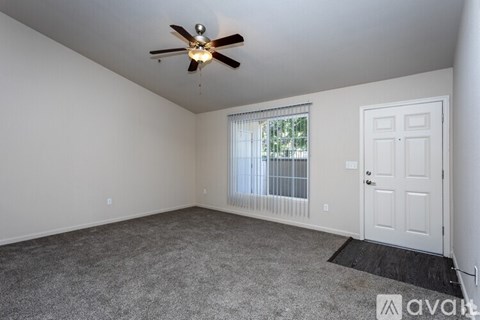 A room with a ceiling fan and a door.