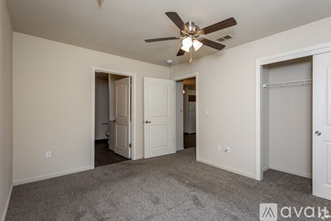 A room with a ceiling fan and carpeted floor.