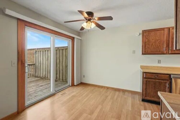 A room with a ceiling fan and sliding glass doors leading to a deck.