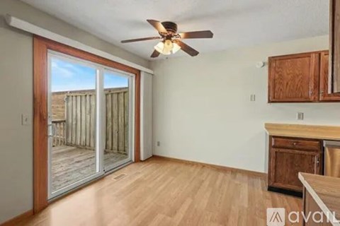 A room with a ceiling fan and sliding glass doors leading to a deck.
