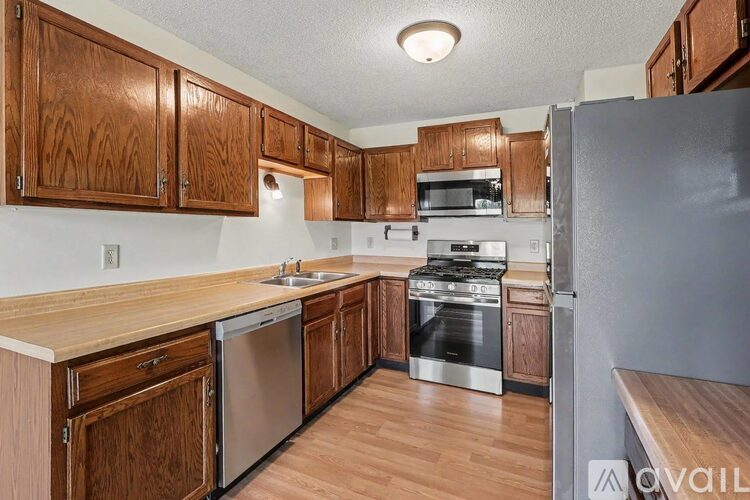 A kitchen with wooden cabinets and stainless steel appliances.
