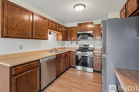 A kitchen with wooden cabinets and stainless steel appliances.