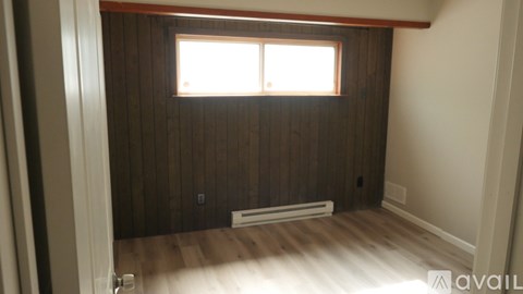 A room with wooden walls and a window.