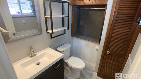 A bathroom with a toilet, sink, and medicine cabinet.