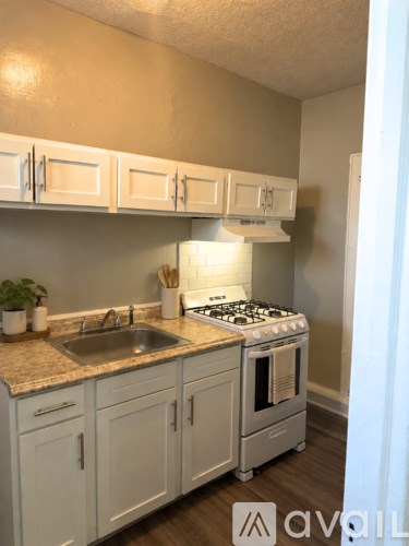 A kitchen with white cabinets and a granite countertop.