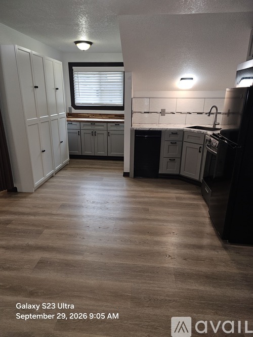 A kitchen with wooden floors and white cabinets.