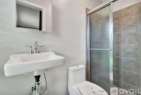 A white sink with a chrome faucet is on a stand in a bathroom.