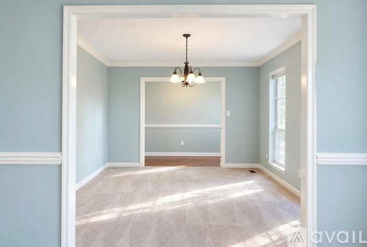 A room with a chandelier and a window.