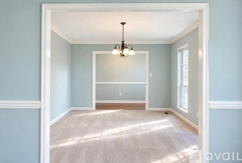 A room with a chandelier and a window.