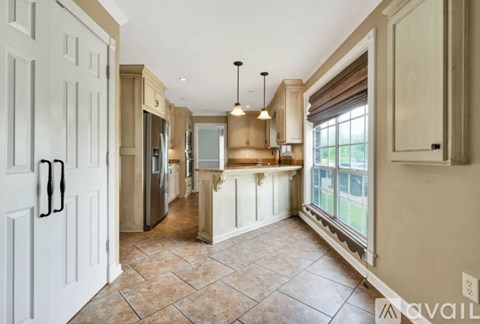 A kitchen with a tile floor and a refrigerator.