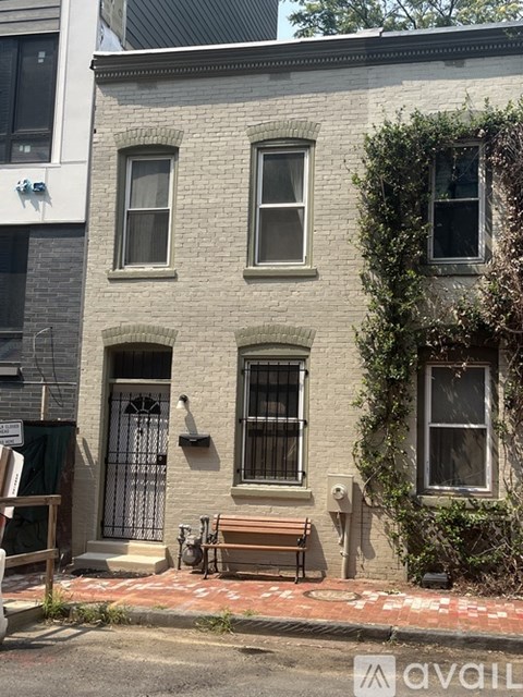 A grey building with a bench in front of it.