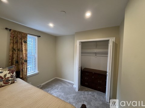 A bedroom with a bed, window, and closet.