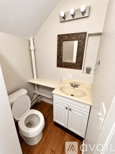 A white toilet sits next to a sink in a small bathroom.