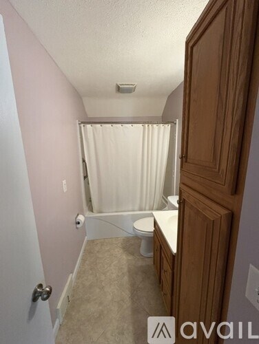 A bathroom with a toilet, sink, and shower.