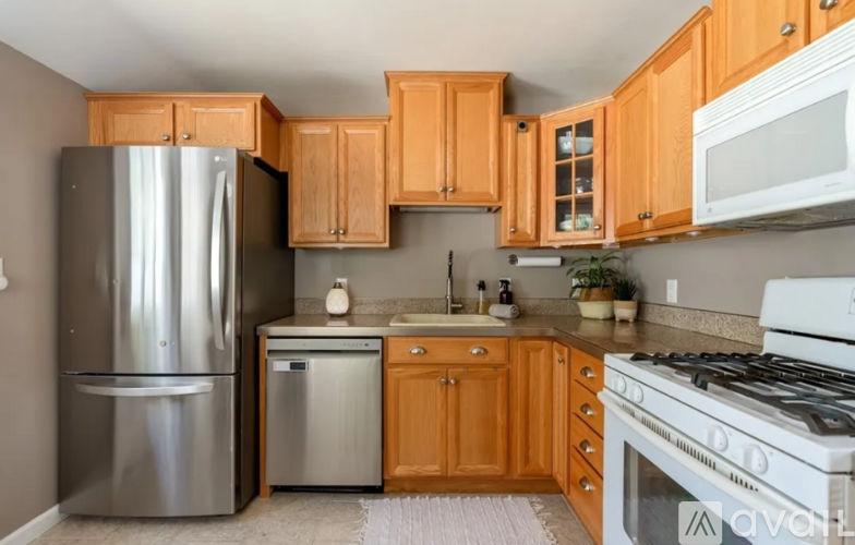 A kitchen with wooden cabinets and a stainless steel refrigerator.
