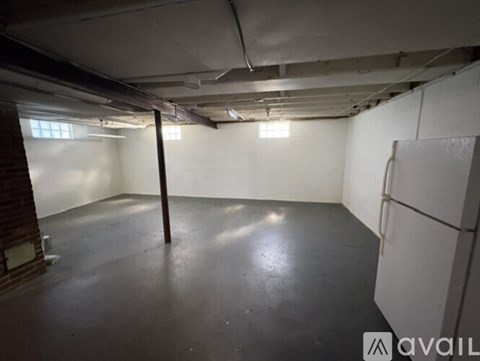 A spacious empty room with a concrete floor and white walls.