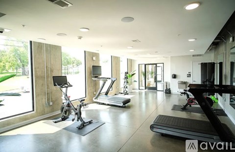 A gym with a treadmill, exercise bike, and other equipment.