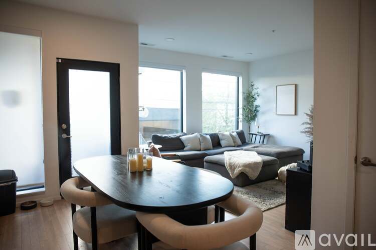A modern dining room with a black table and chairs.