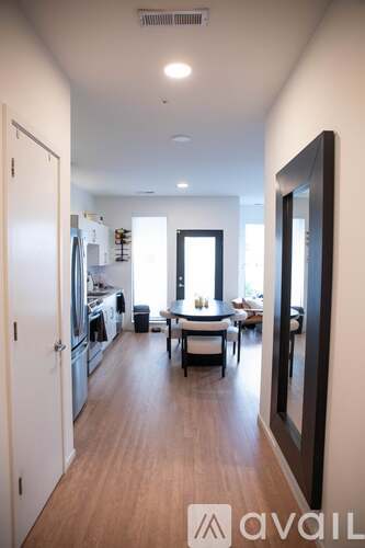 A kitchen with a dining table and chairs is visible through an open door.