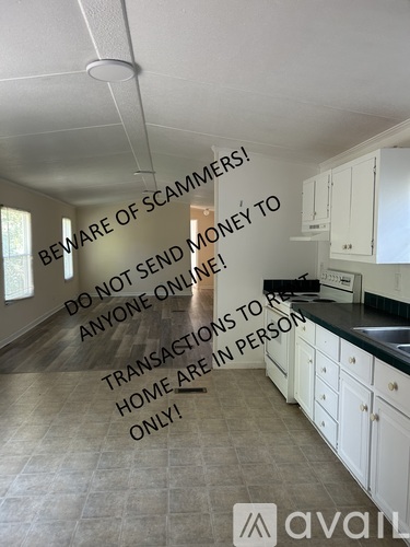 A kitchen with a warning sign about scammers and transactions being in person only.