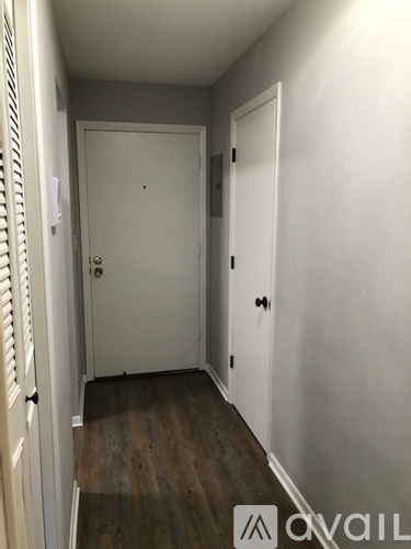 A hallway with two doors and a wooden floor.