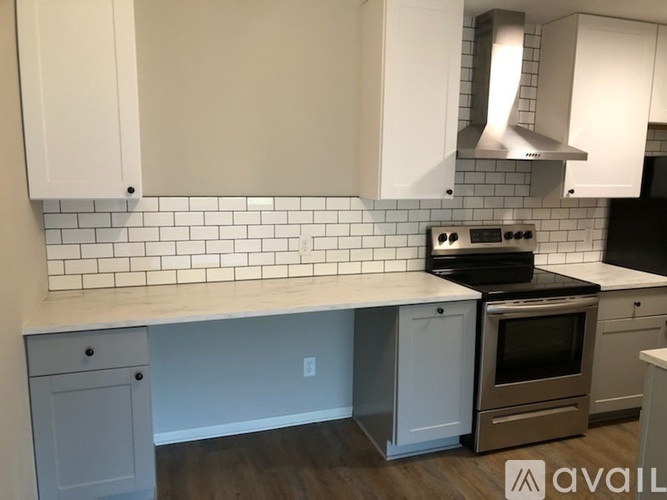 A kitchen with white cabinets and a stove top oven.