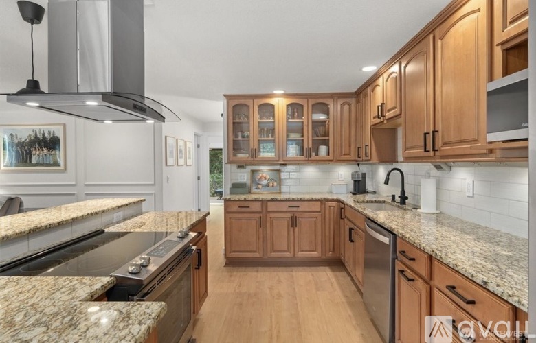 A kitchen with wooden cabinets and granite countertops.