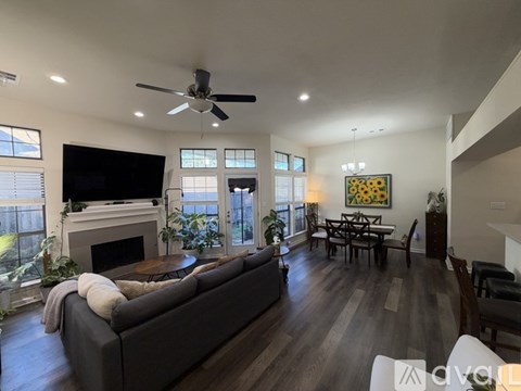 A living room with a grey couch and a fireplace.