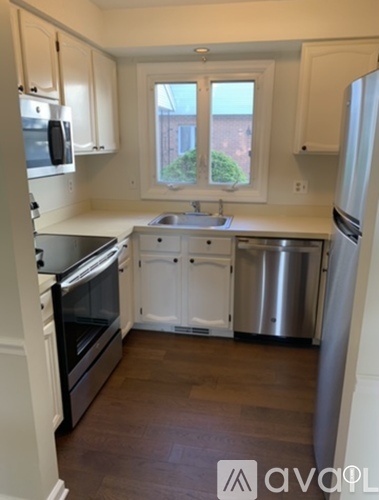 A kitchen with white cabinets and a window.