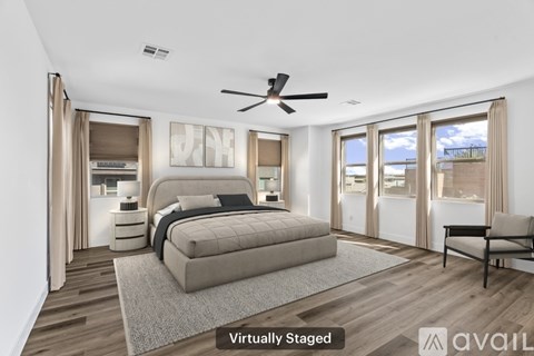 A bedroom with a bed, a chair, and a ceiling fan.