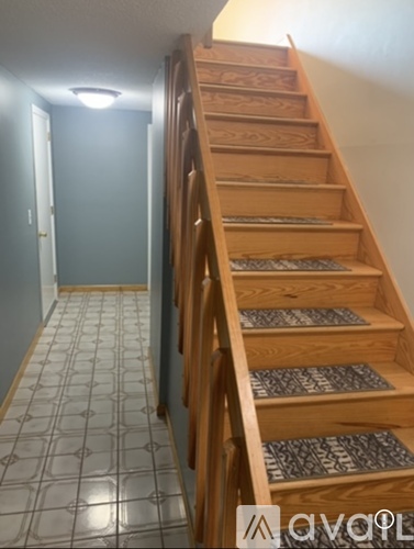A wooden staircase with a tiled floor.