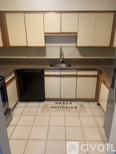 A kitchen with a sink and a mat on the floor that says "Heals, Memories".