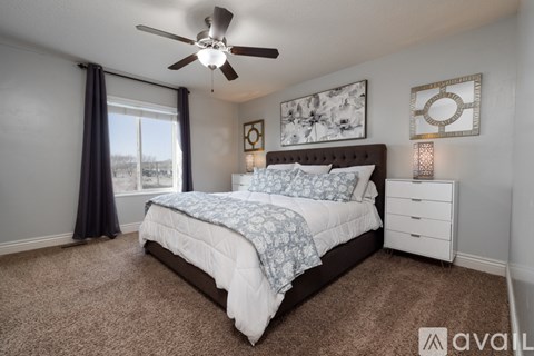A bedroom with a large bed and a ceiling fan.