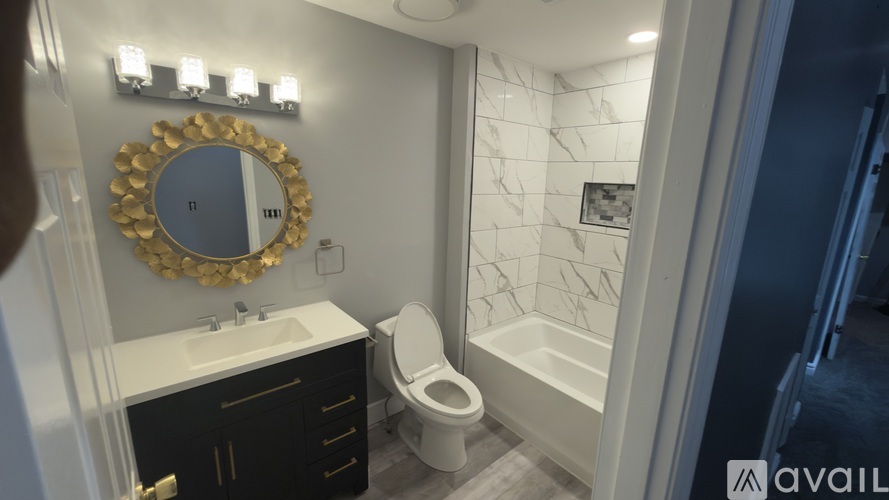 A bathroom with a toilet, sink, and mirror.