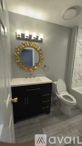 A bathroom with a toilet, sink, and mirror.