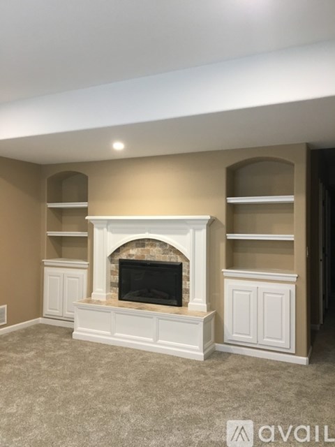 A living room with a fireplace and built-in shelves.