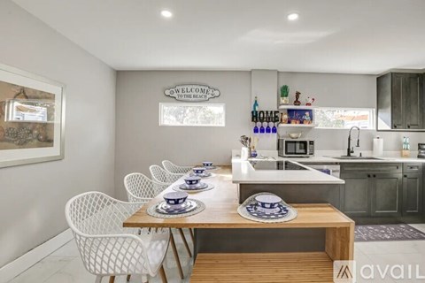 A modern kitchen with a dining table set for four.