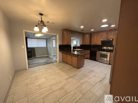 A kitchen with wooden cabinets and a black countertop.